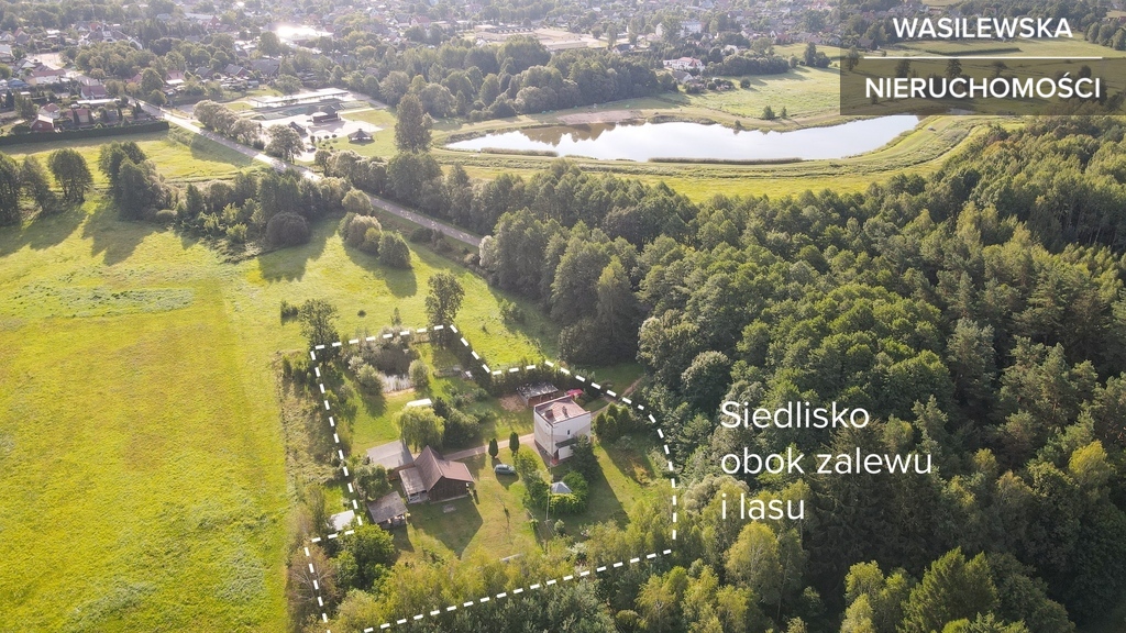 Siedlisko z dwoma domami obok zalewu i lasu
